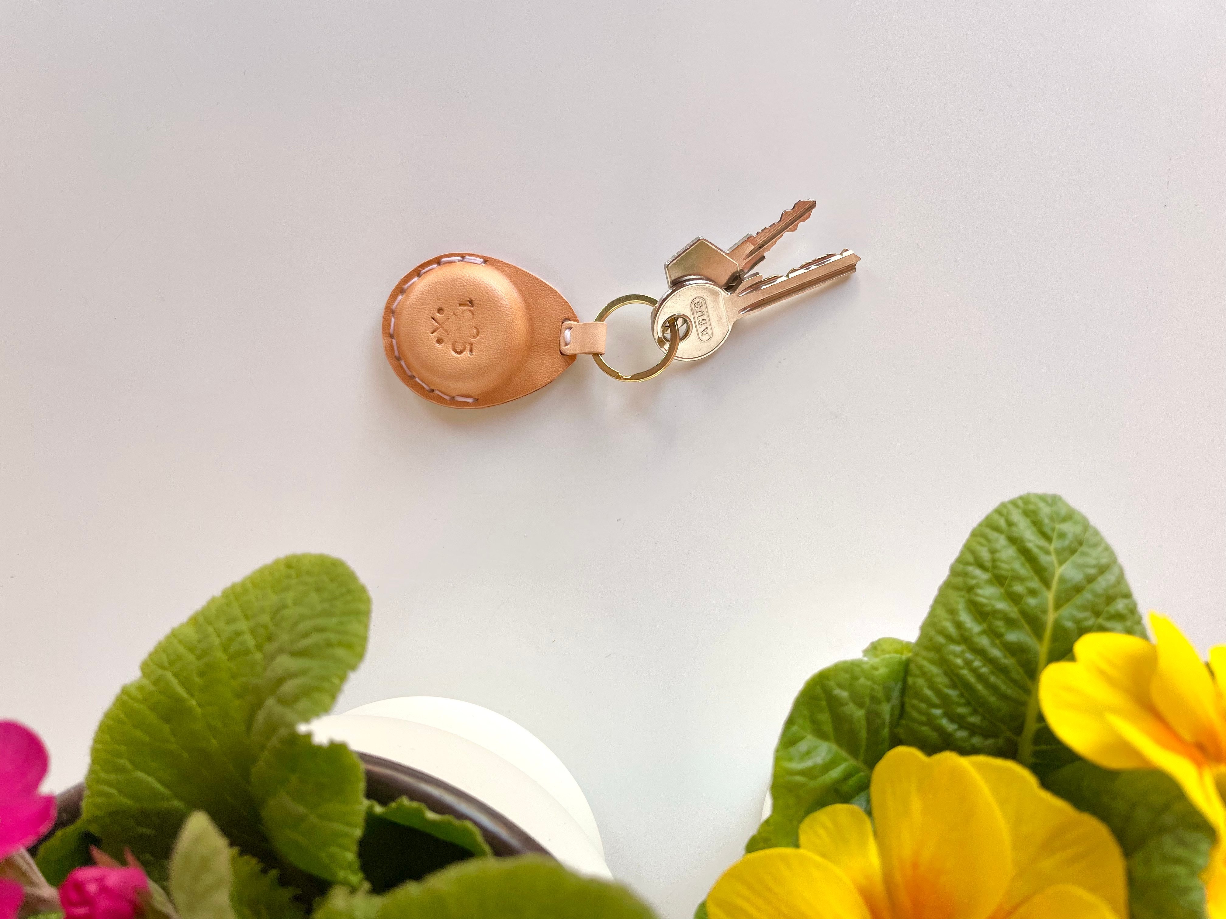 Teardrop AirTag key fob by 1985 Studio in wet-molded vegetable-tanned leather, hand-stitched with contrast thread, its brass ring holding two keys